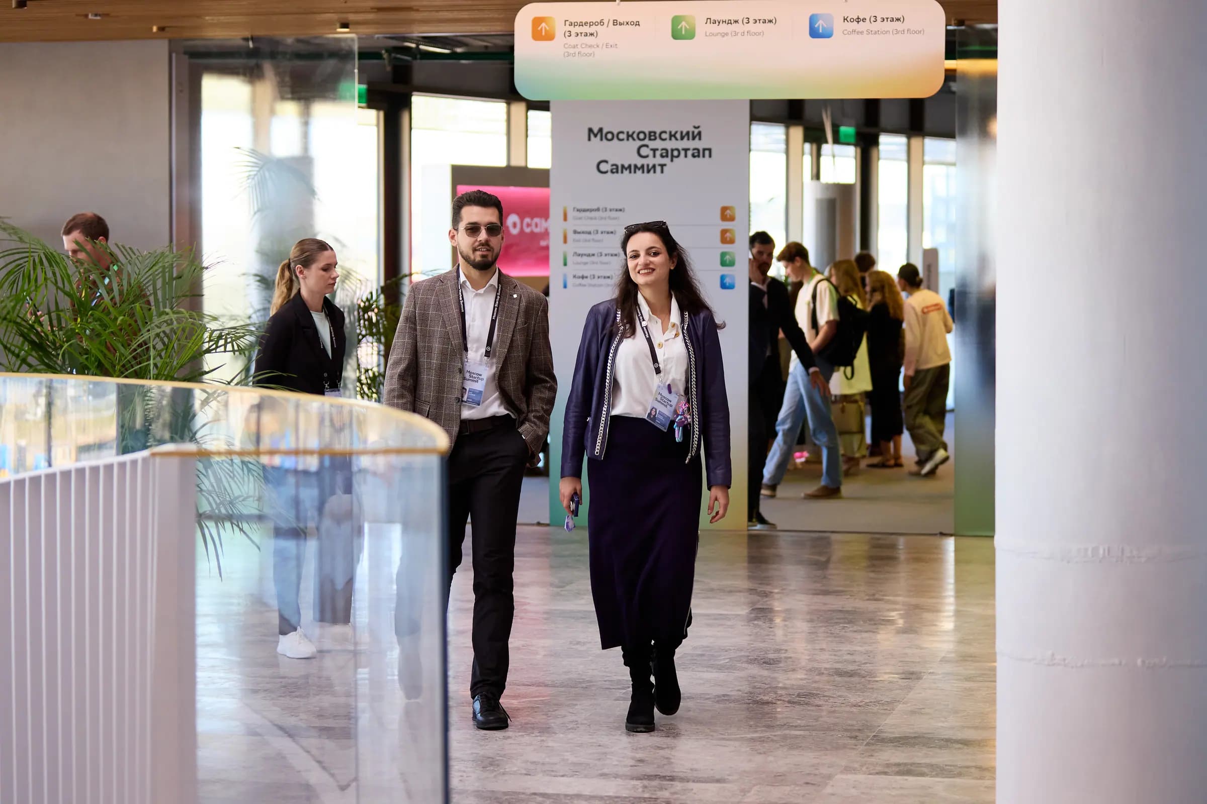 Moscow Startup Summit attendees walking through the venue under wayfinding signs